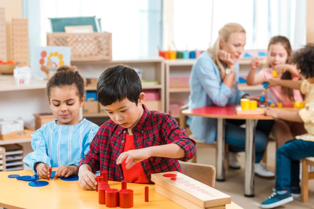 Selective focus of kids playing games with children and teacher